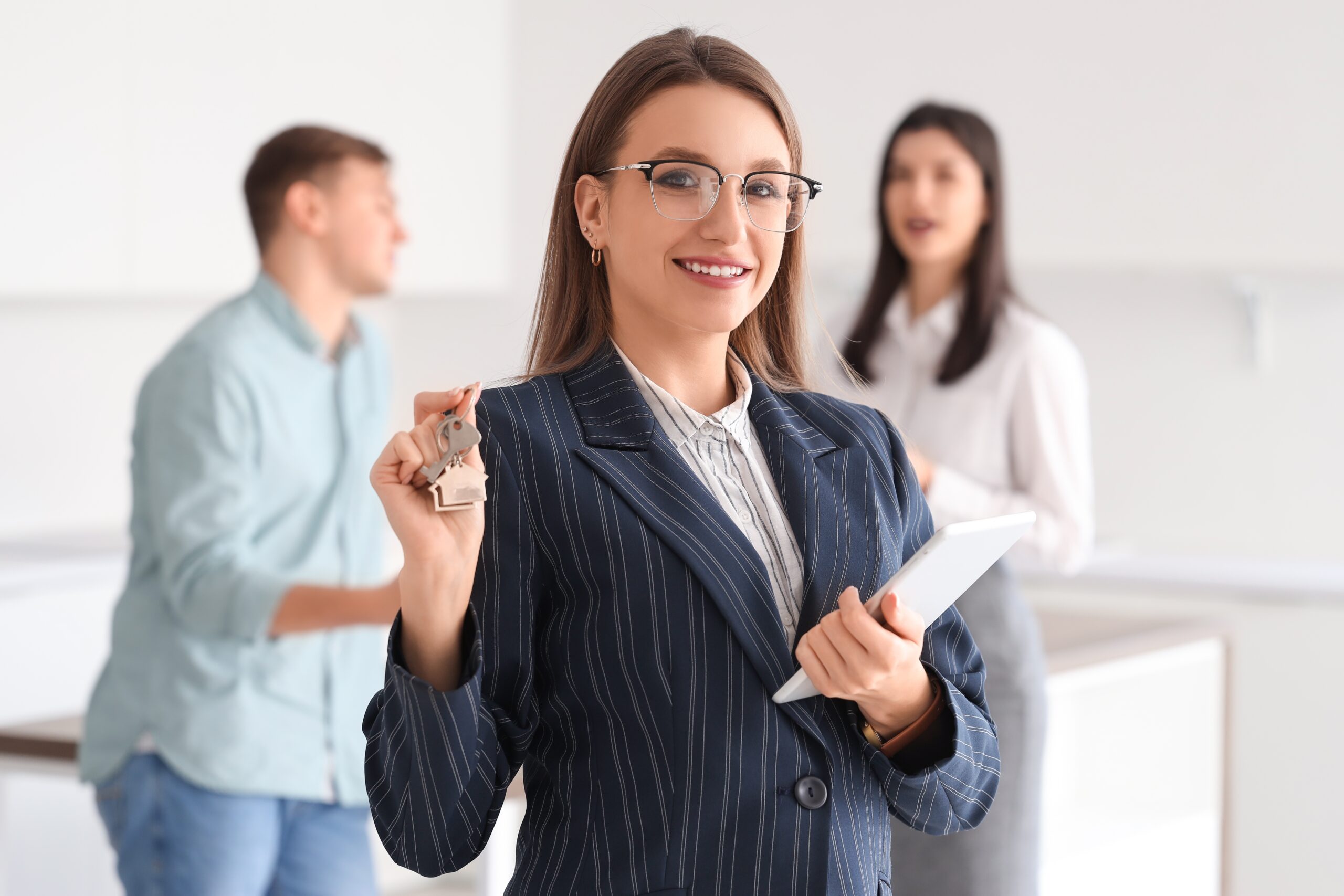 Saleswoman holding a laptop with clients in the background